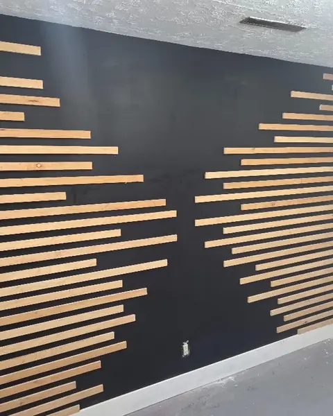 Black wall with geometric light wood slats finished