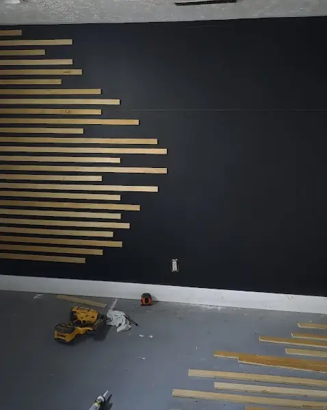 Wood slat accent wall in progress with tools on the floor