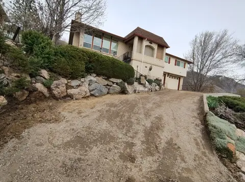 Dirt driveway on an incline beside a rock wall