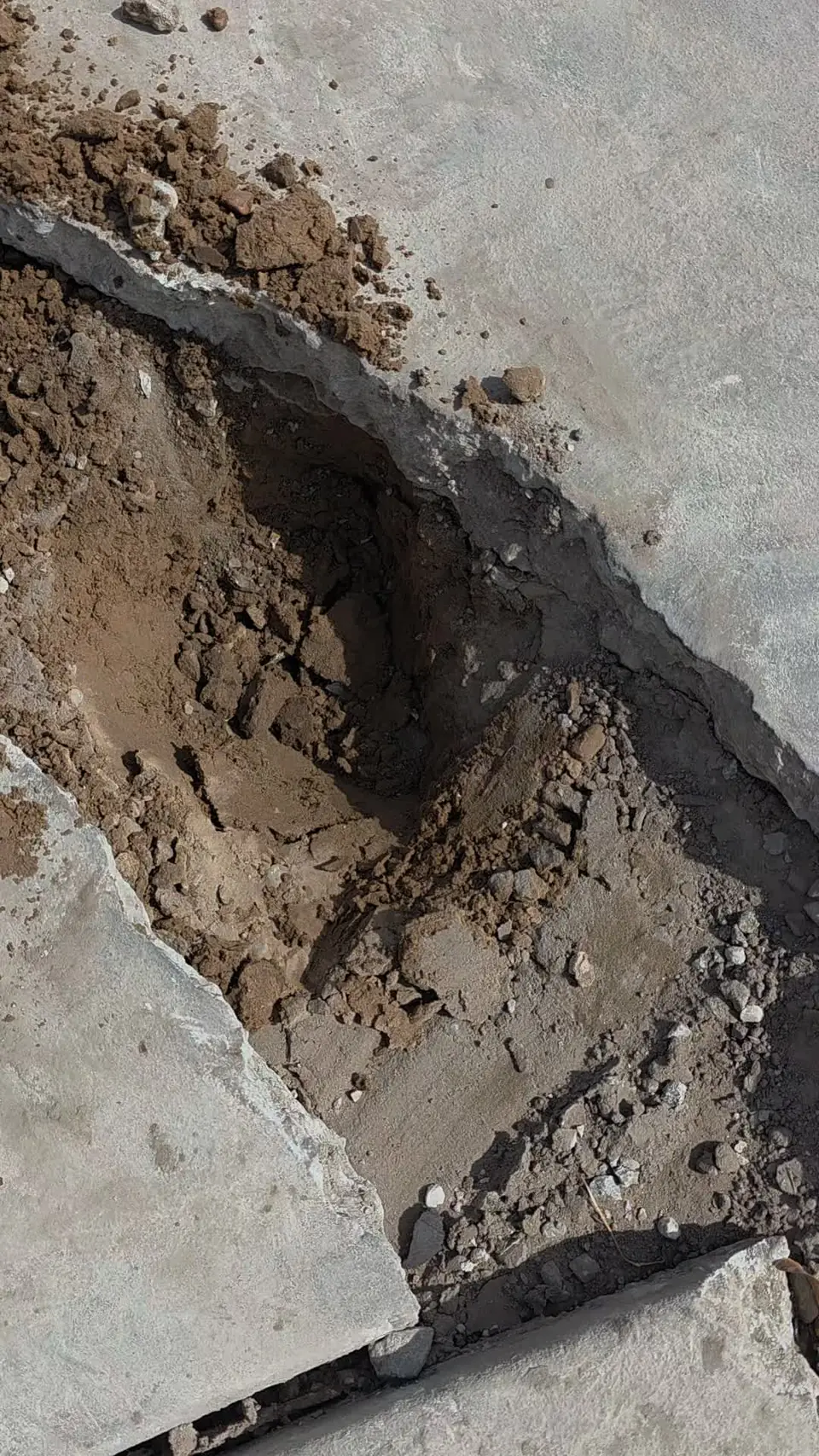 Opened concrete slab showing the void and ground prep underneath